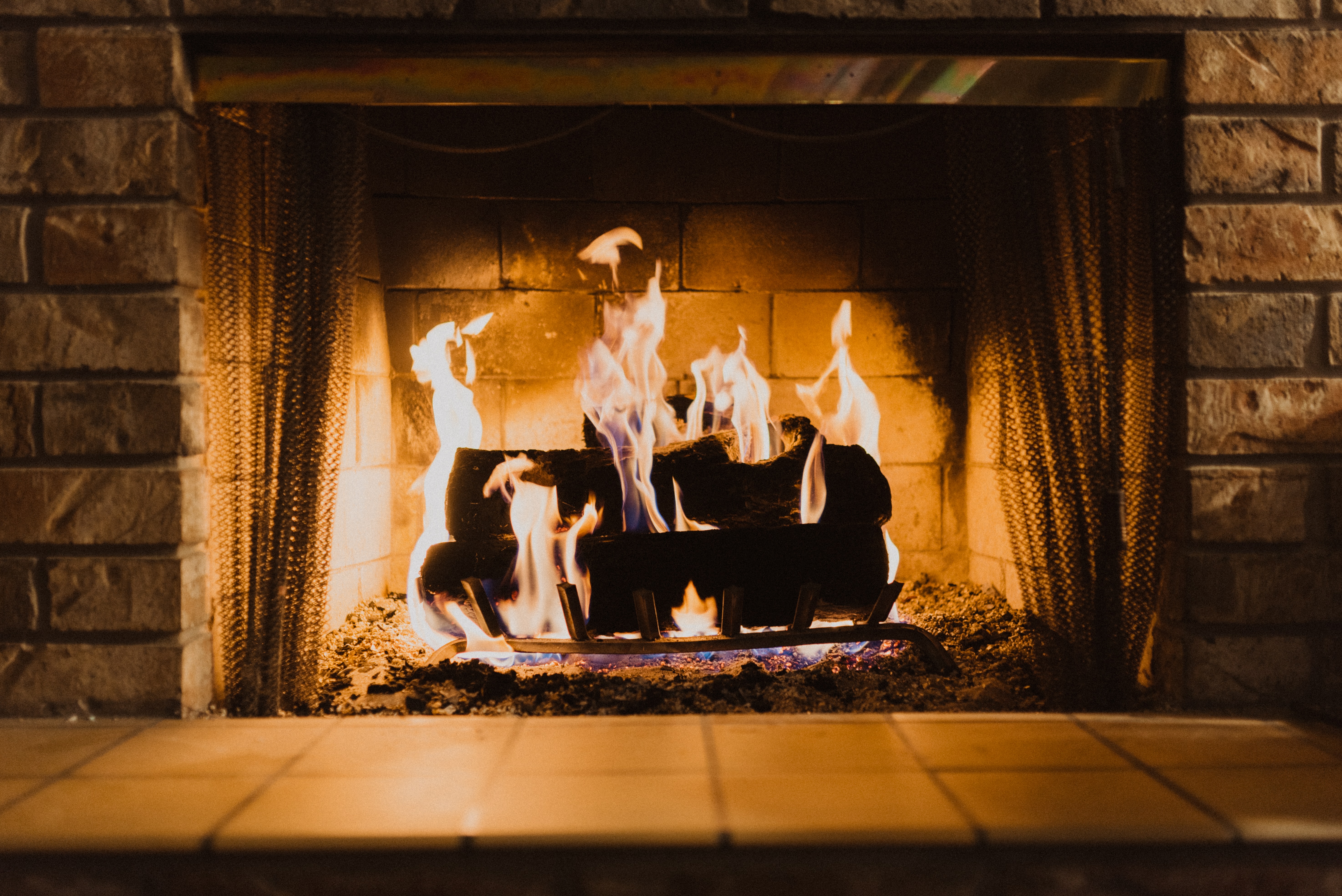 Roaring fire in a brick fireplace with tile hearth 